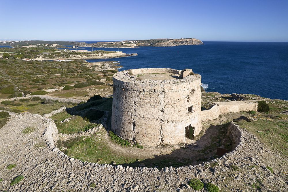 Foto aérea de la torre d'en penjat con la Mola de Maó al fondo. Menorca británica